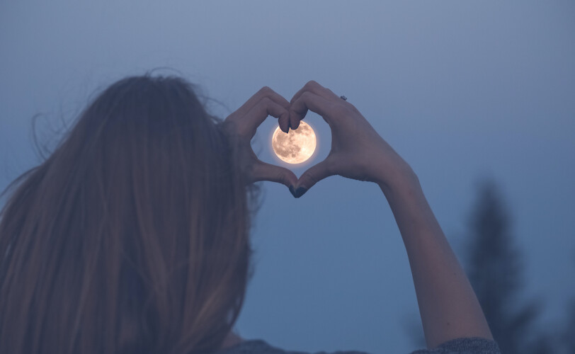 Woman with hands around the moon